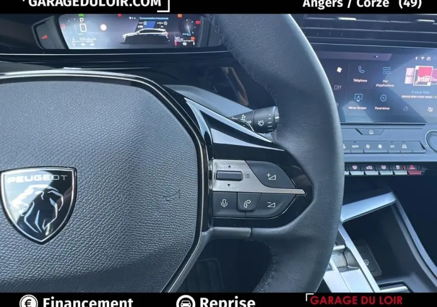 Gros plan sur le volant cuir noir de la Peugeot 308 2023 avec commandes multifonctions et tableau de bord digital.