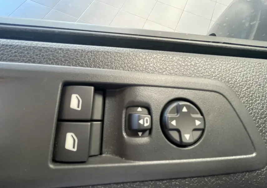 Gros plan sur les commandes de réglage des vitres et des rétroviseurs côté gauche du Peugeot Traveller noir.