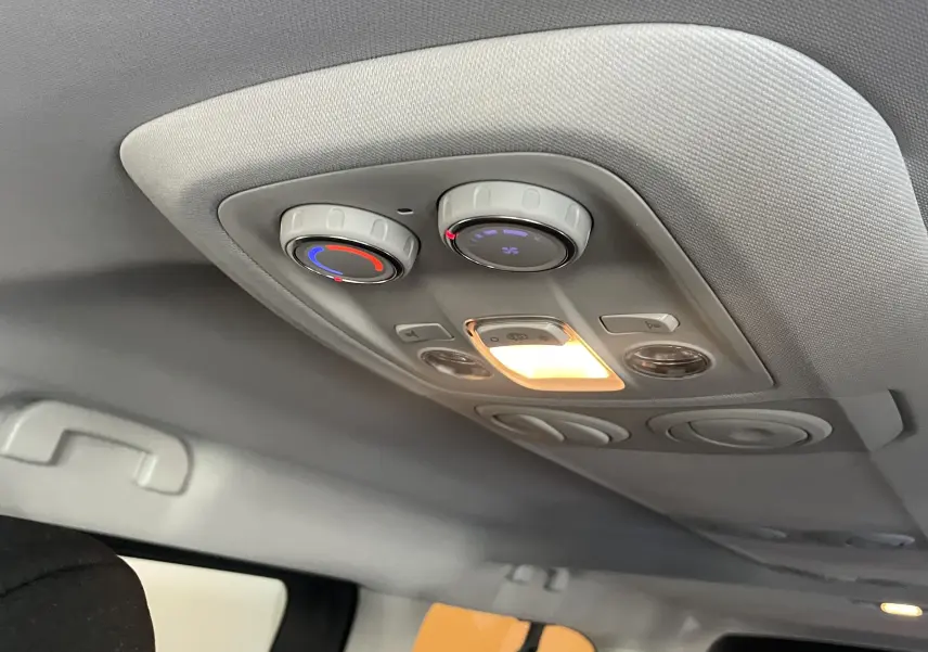 Vue intérieure du plafond arrière du Peugeot Traveller noir 2026, avec commandes de climatisation et éclairage intégré allumé.