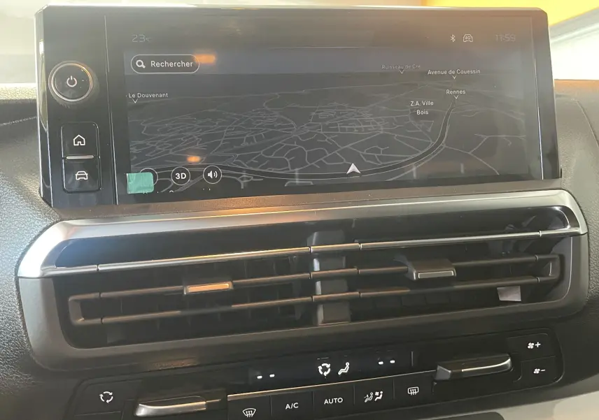 Vue rapprochée de l’écran tactile central du Peugeot Traveller noir 2026 avec navigation et commandes climatisation visibles.