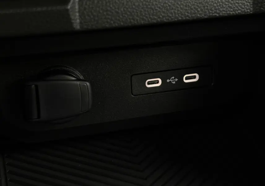 Gros plan sur les deux ports USB-C et prise 12V dans l'habitacle du Dacia Duster gris Schiste 2026.