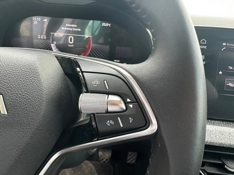 Gros plan sur les commandes gauche du volant cuir noir du Skoda Scala gris argent 2025 avec écran multifonction en arrière-plan.