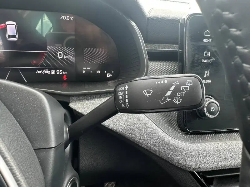 Gros plan sur la commande des essuie-glaces dans l'habitacle gris argenté d'une Skoda Scala 2025, avec tableau de bord numérique.