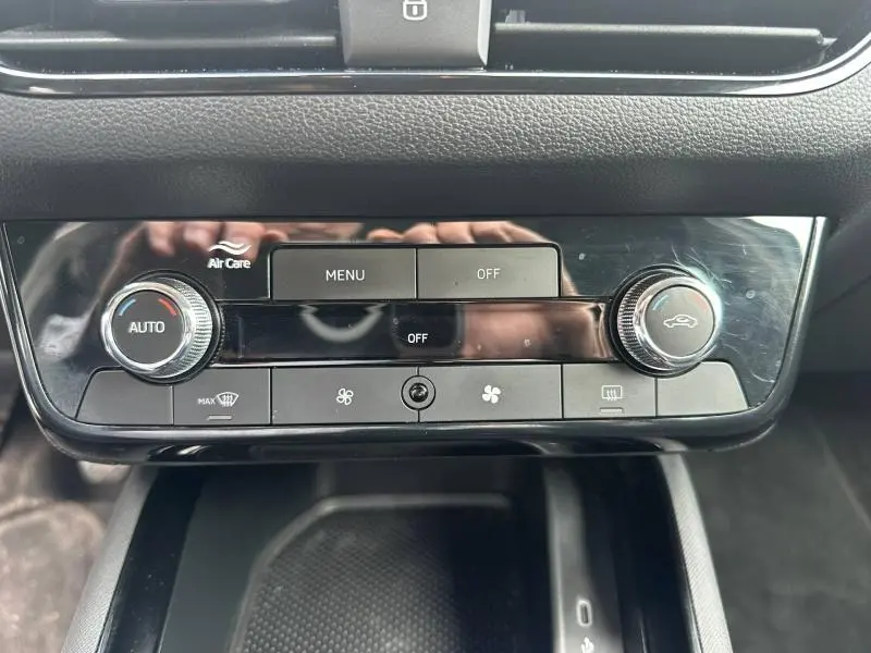 Vue rapprochée de la console centrale noire brillante du Skoda Scala 2025 avec commandes climatisation et ventilation.