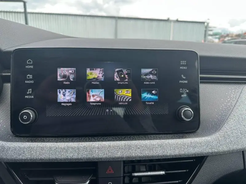 Écran tactile central du tableau de bord gris argenté de la Skoda Scala 1.0 TSI Evo2, affichant le menu multimédia.
