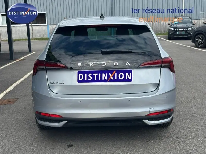 Vue arrière d'une Skoda Scala gris argent métallisé avec feux arrière LED et logo SKODA visible.