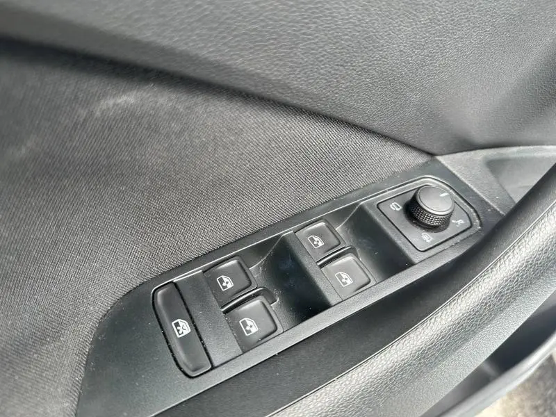 Commande des vitres électriques et réglage des rétroviseurs côté conducteur dans une Skoda Scala gris argent métallisée.