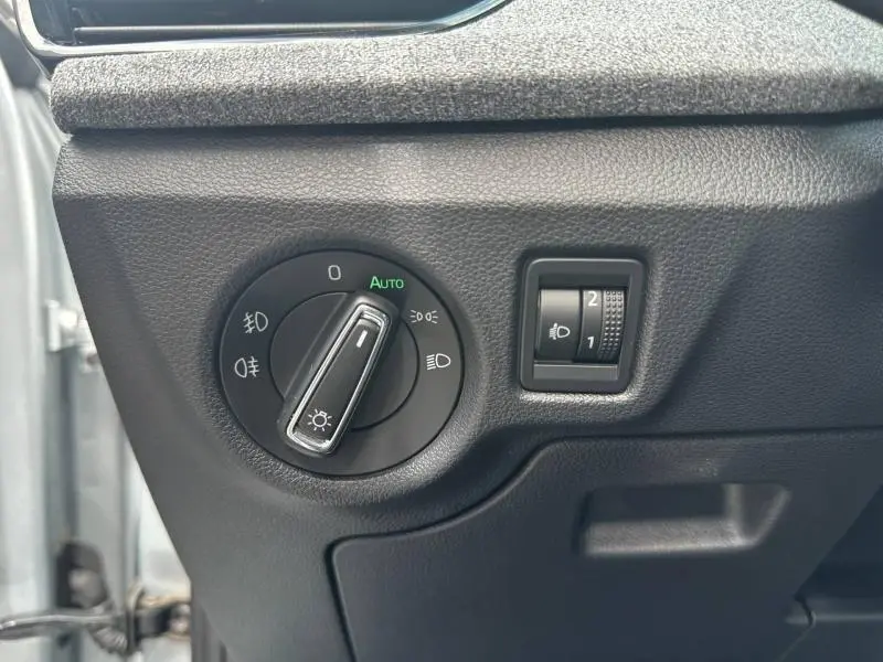 Détail du réglage des phares avec molette et bouton de réglage d'intensité sur tableau de bord noir d'une Skoda Scala gris argent.