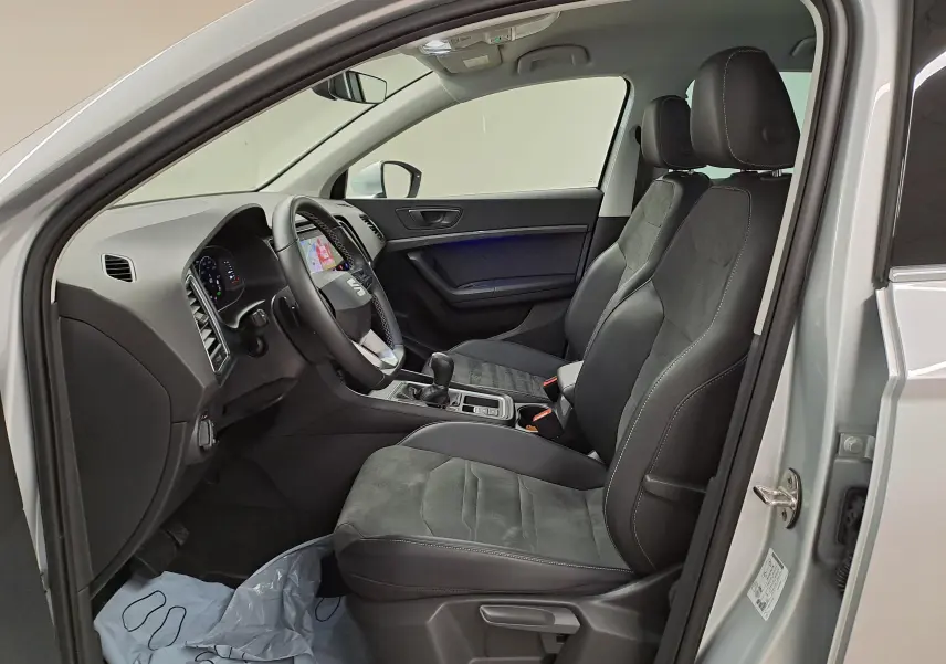 Vue intérieure côté conducteur du SEAT Ateca 2.0 TDI argent, sièges en tissu et alcantara avec console centrale visible.