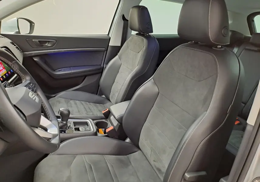 Vue intérieure côté gauche du SEAT Ateca 2.0 TDI 150 DSG7 Copa, sièges en cuir et alcantara gris avec surpiqûres blanches.