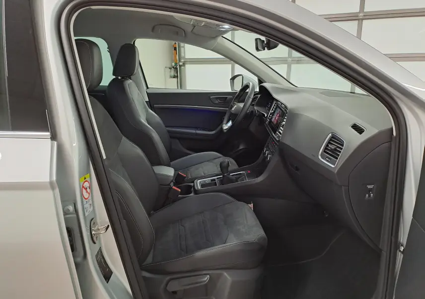 Vue intérieure côté conducteur du SEAT Ateca 2.0 TDI 150 DSG7 Copa argent, avec sièges noirs et tableau de bord moderne.