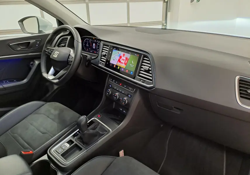 Intérieur du SEAT Ateca 2025 vu côté conducteur, tableau de bord moderne avec écran tactile et sellerie noire.