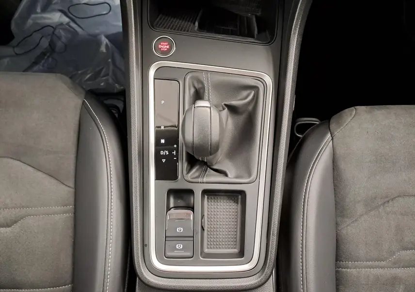 Vue plongeante sur la console centrale du SEAT Ateca 2.0 TDI 150 DSG7 avec levier de vitesse et sièges en tissu gris.