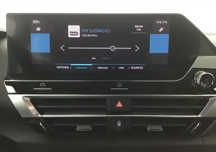 Tableau de bord du Citroën C4 noir 2022, vue frontale sur l'écran tactile affichant la radio FM Sud Radio.