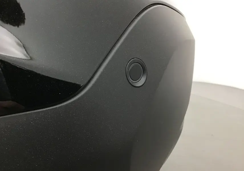 Gros plan sur le capteur de stationnement arrière du pare-chocs noir d'une Citroën C4 2022 finition Feel Pack.