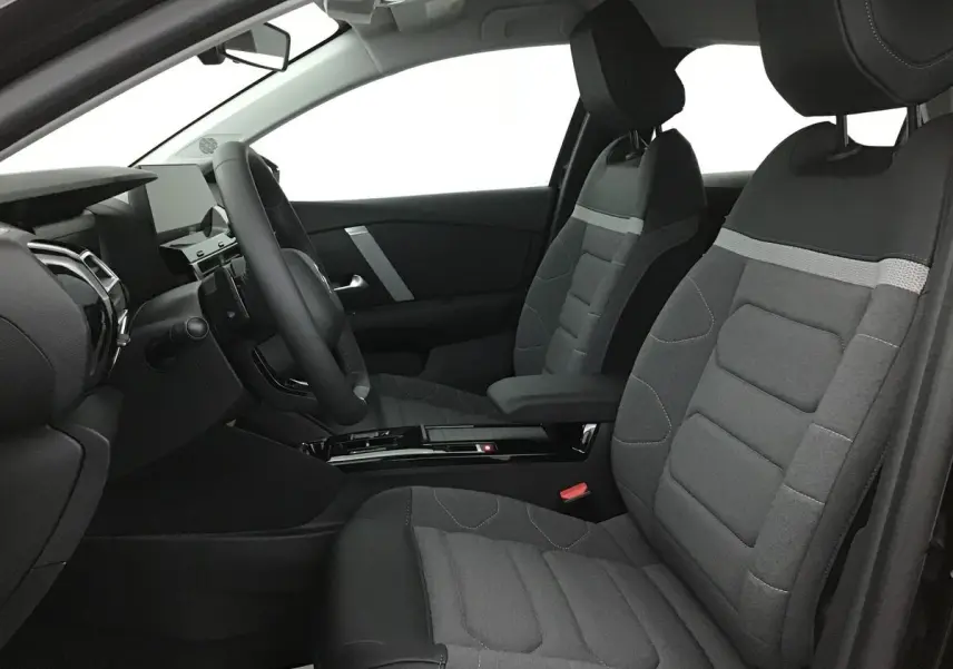 Vue intérieure côté conducteur de la Citroën C4 2022 avec sièges tissu gris et tableau de bord moderne noir.