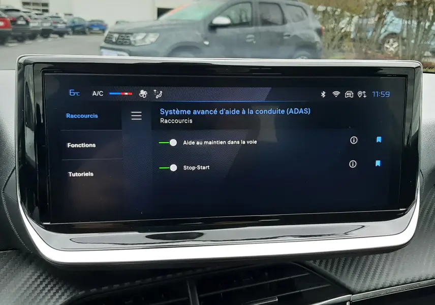 Écran tactile central du Peugeot 208 2024 affichant les aides à la conduite, avec tableau de bord noir et finition carbone.