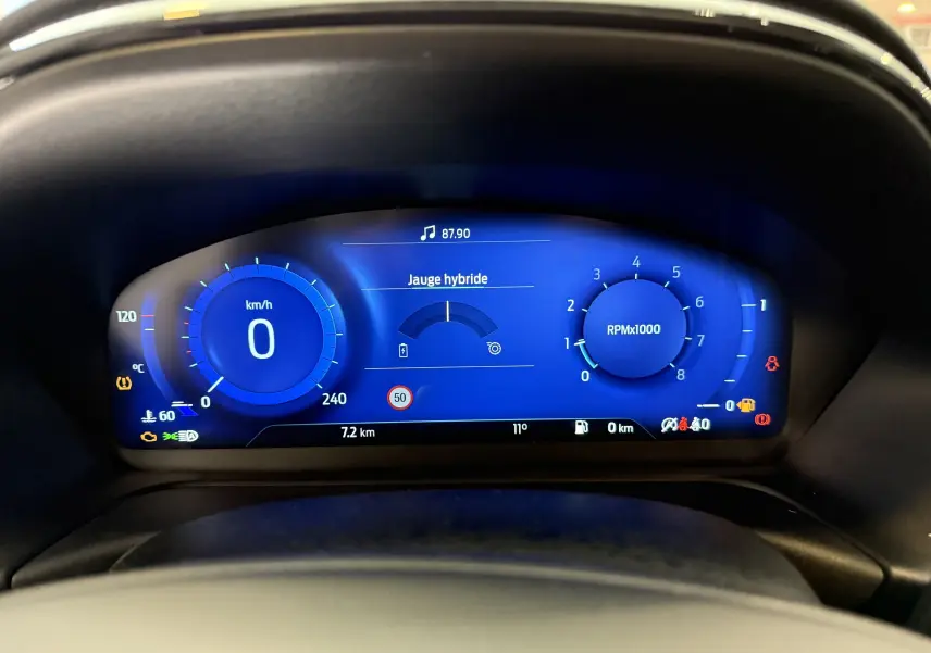 Vue rapprochée du tableau de bord numérique bleu du Ford Puma 2022 affichant la vitesse, le régime moteur et la jauge hybride.