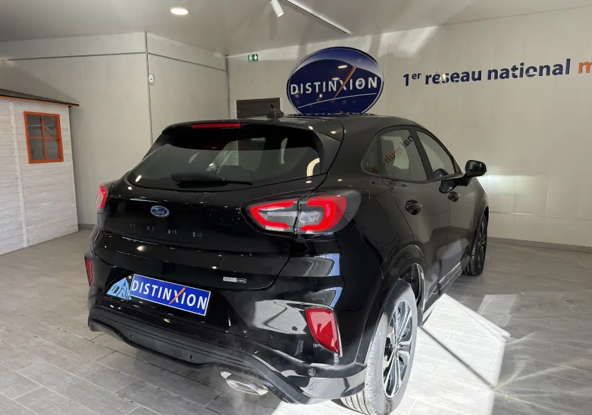 Vue 3/4 arrière droite d'une Ford Puma noire Agate 2022 avec feux LED et jantes alliage en showroom.