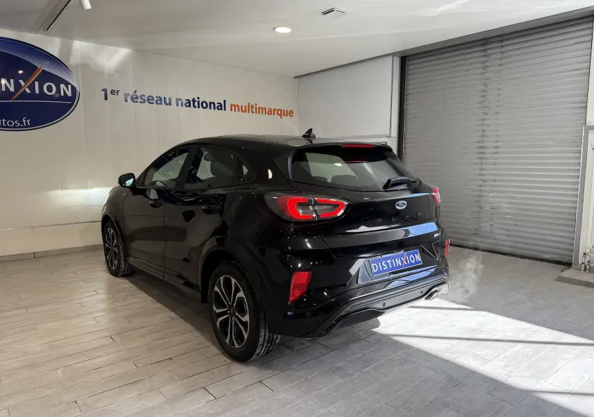 Vue 3/4 arrière droite d'un Ford Puma noir Agate avec feux LED et jantes alliage dans un showroom.