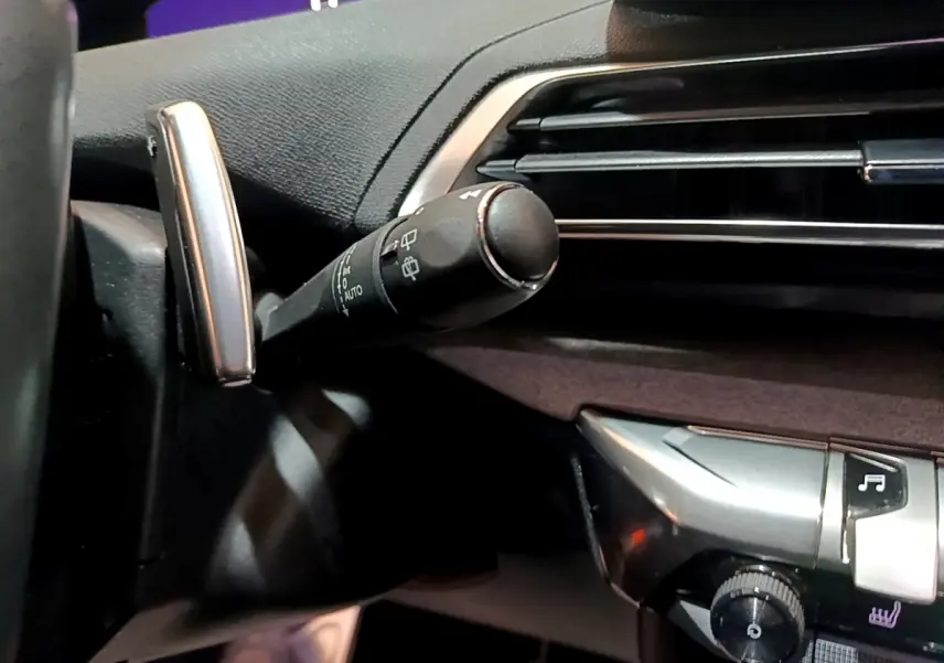 Gros plan sur la commande d’essuie-glace à gauche du volant dans l’habitacle noir du Peugeot 3008 GT 2023.