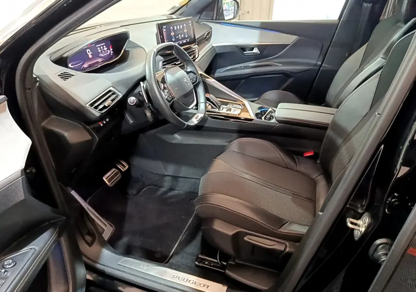 Intérieur noir du Peugeot 3008 GT 2023, vue côté conducteur, volant cuir et tableau de bord numérique lumineux.