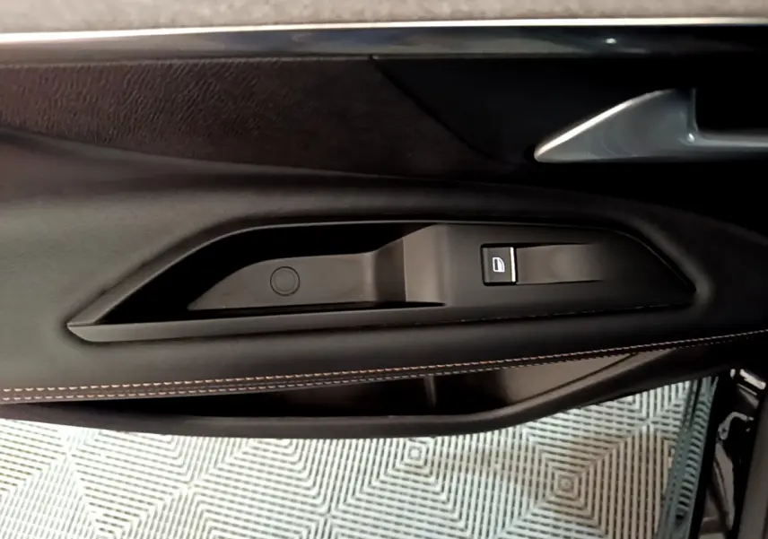 Poignée intérieure côté gauche de la porte noire du Peugeot 3008 GT 2023 avec bouton de verrouillage intégré.