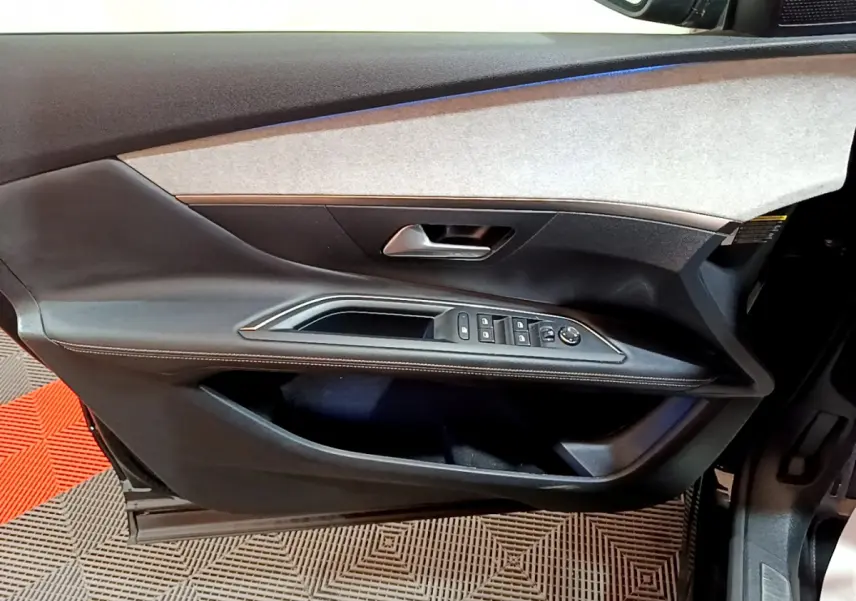 Vue rapprochée de la porte avant gauche noire du Peugeot 3008 2023, avec commandes électriques et poignée argentée.