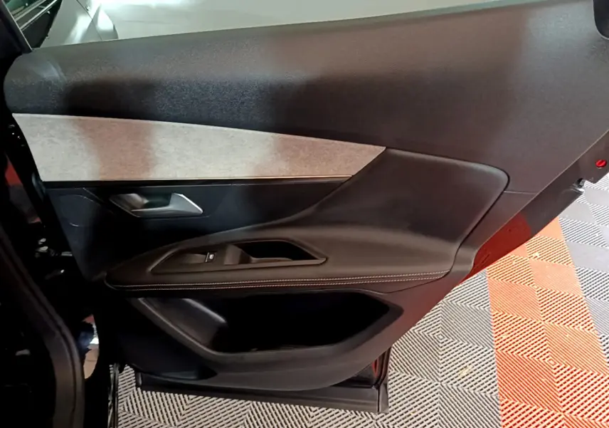 Gros plan sur la porte intérieure côté gauche noire et grise du Peugeot 3008 GT 2023 avec surpiqûres blanches.