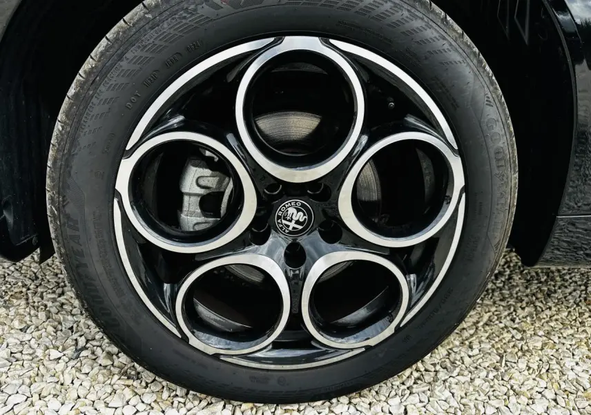 Gros plan sur la roue arrière droite d'une Alfa Romeo Tonale bleu métallisé, avec pneu Goodyear visible.