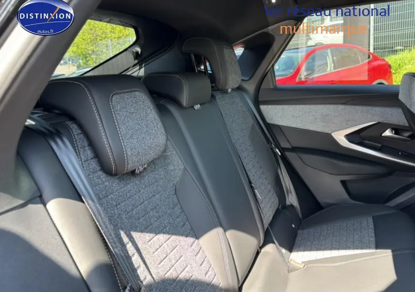 Vue intérieure sur la banquette arrière du Peugeot 3008 2025, tissu gris et cuir noir, avec porte côté droit visible.