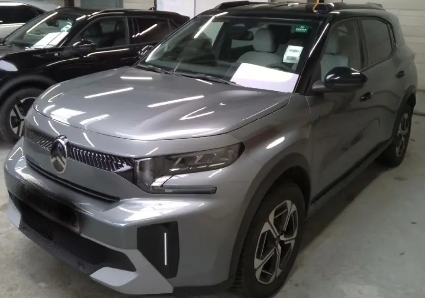 Vue 3/4 avant droit d'un Citroën C3 Aircross électrique gris mercury avec toit noir et jantes 17 pouces.