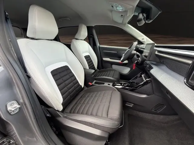 Intérieur avant droit du Citroën C3 Aircross gris mercury, sièges bicolores noir et blanc, tableau de bord moderne.