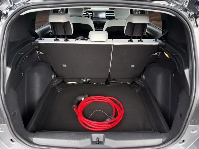 Vue du coffre ouvert d'une Citroën C3 Aircross gris mercury, avec câble de recharge électrique rouge visible à l'intérieur.