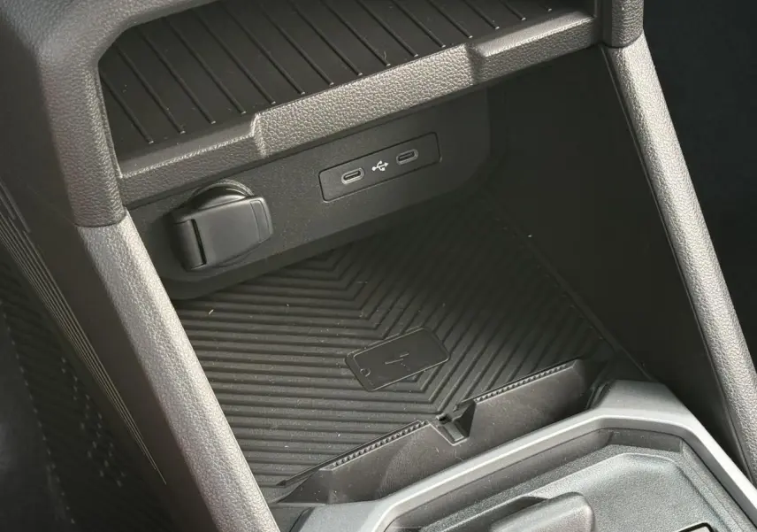 Gros plan sur la console centrale du Dacia Duster 2026, montrant le chargeur à induction et ports USB intégrés.