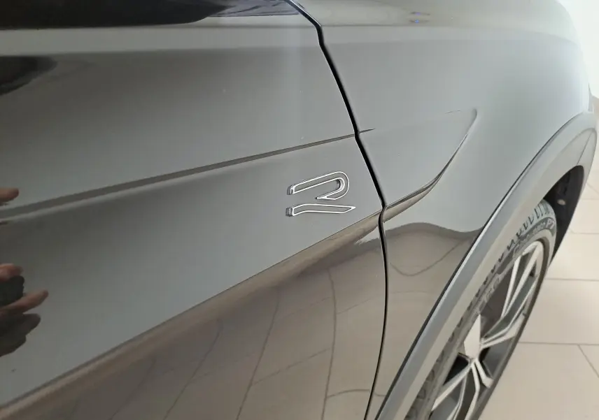 Gros plan sur l'aile avant droite noire intense du Volkswagen Taigo 2025 avec logo R-Line et jante alliage 18 pouces.