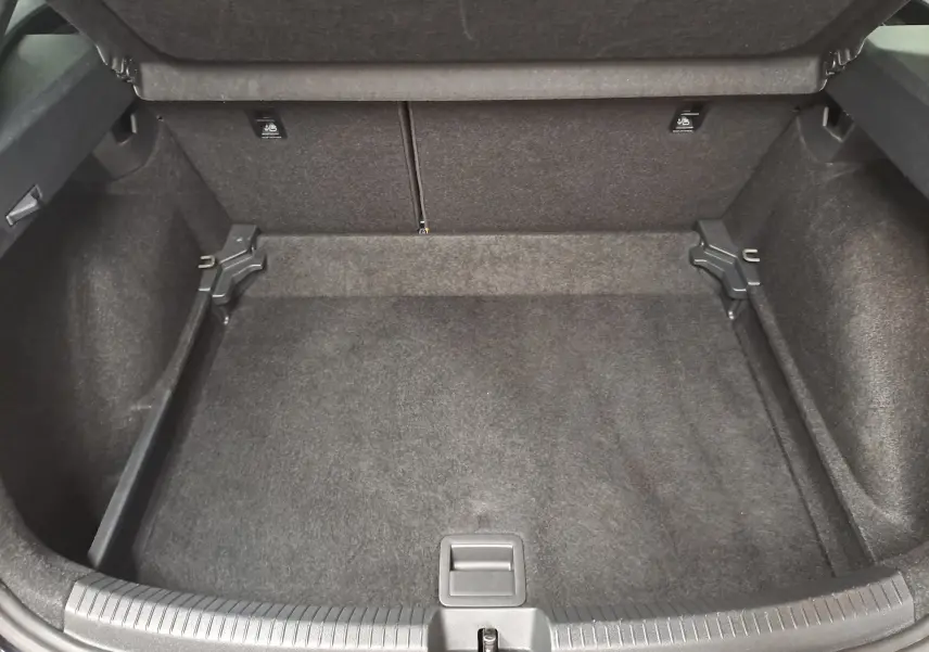 Coffre ouvert vu de face, intérieur spacieux et tapissé de noir du Volkswagen Taigo 2025 noir intense.
