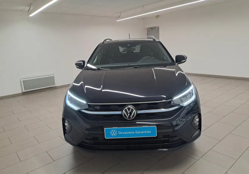 Volkswagen Taigo noir intense 2025 vu de face, avec phares LED allumés et calandre R-Line distinctive.