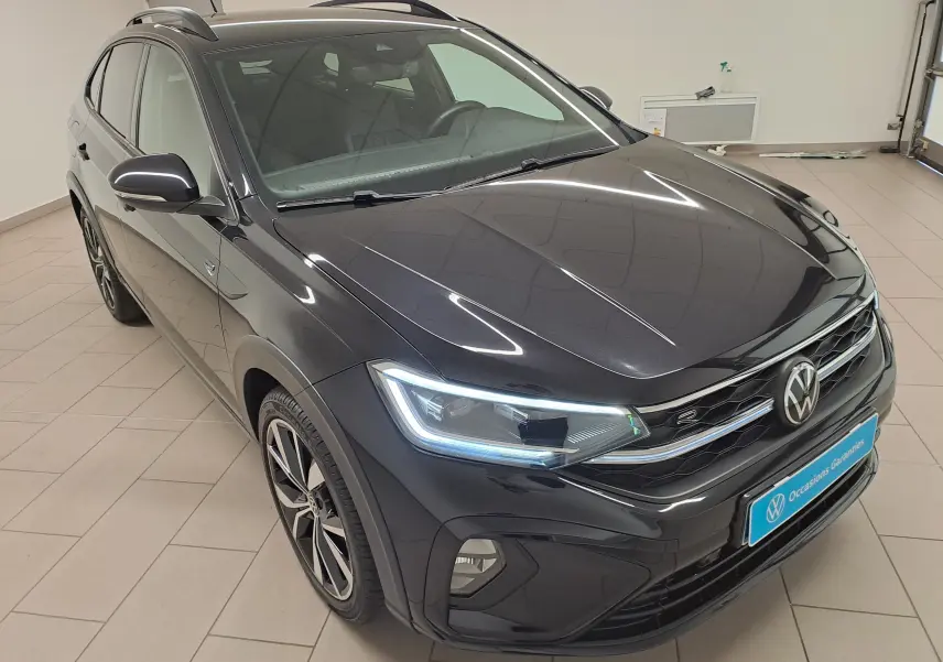 Volkswagen Taigo noir intense en 3/4 avant droit, avec jantes alliage 18'' Misano et phares LED allumés.