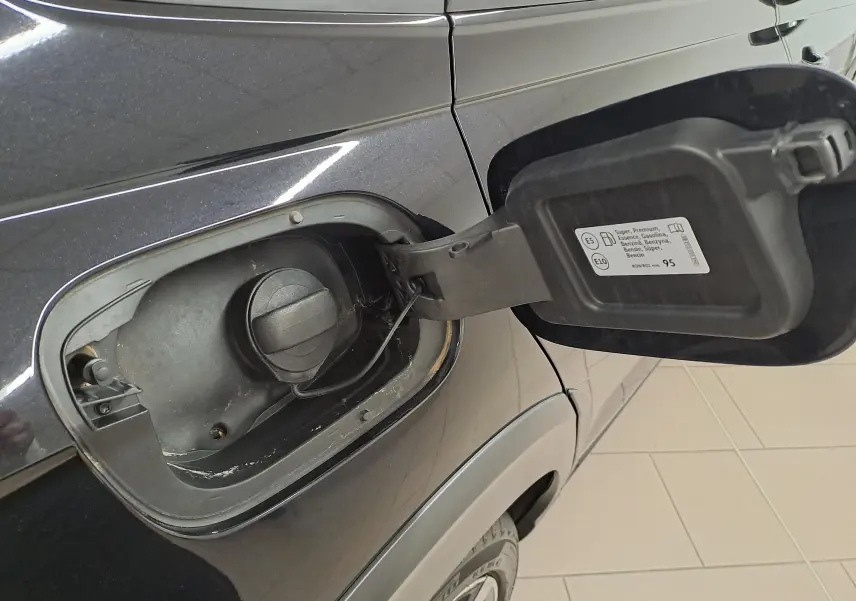 Gros plan sur la trappe à carburant ouverte côté gauche d’un Volkswagen Taigo noir intense 2025.