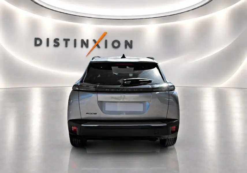 Vue arrière d'un Peugeot 2008 gris artense dans un showroom avec logo Distinxion en fond.