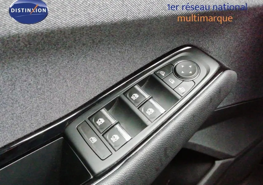 Gros plan sur les commandes de lève-vitres et rétroviseurs côté conducteur d’un Renault Austral gris schiste.