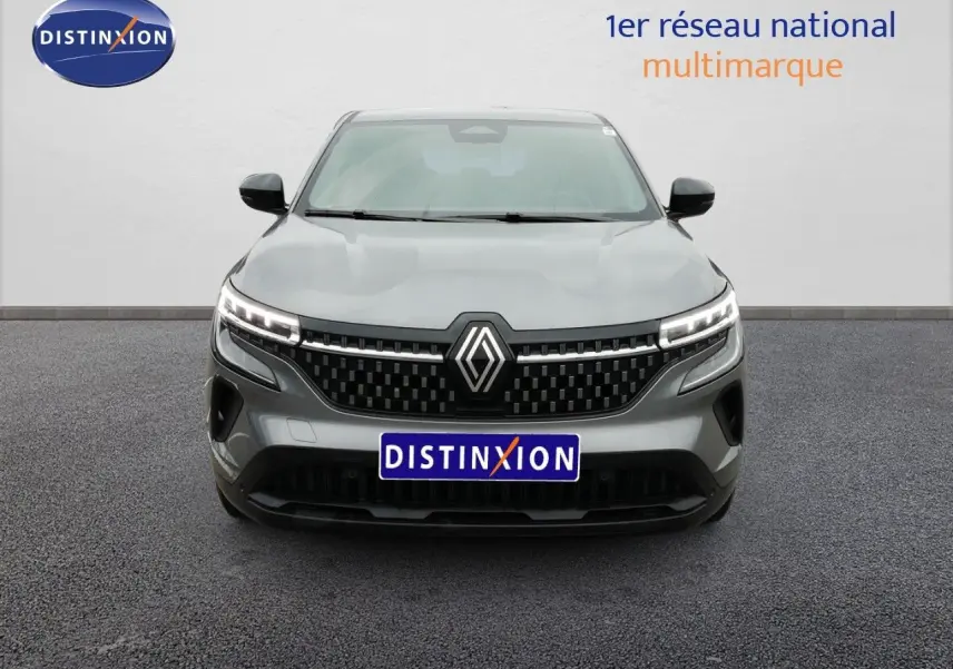 Vue de face du Renault Austral gris schiste métal avec calandre noire et feux LED allumés sur fond neutre.