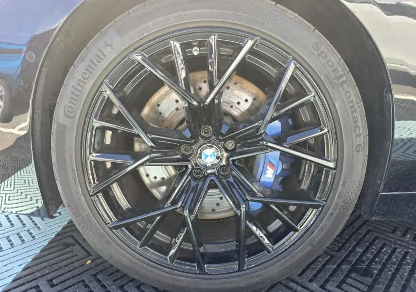 Gros plan sur la jante noire brillante 20'' style 813 M avec étrier de frein bleu M de la BMW Série 8 Cabriolet M8 Competition.