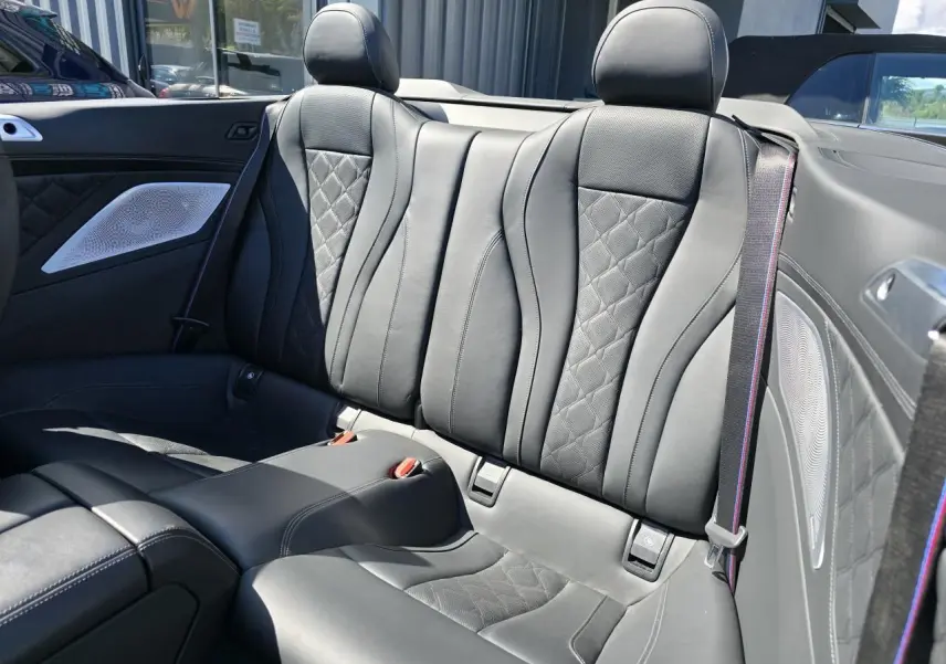 Vue rapprochée des sièges arrière en cuir noir avec surpiqûres losanges du cabriolet BMW Série 8 M8 Competition 2021.