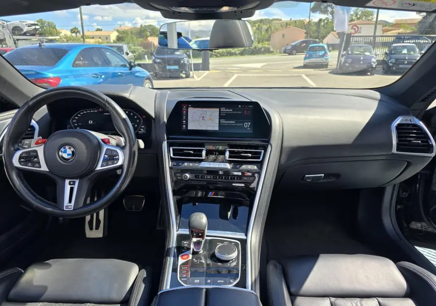 Intérieur noir cuir de la BMW Série 8 Cabriolet M8 Competition 2021, vue frontale sur tableau de bord et volant M sport.