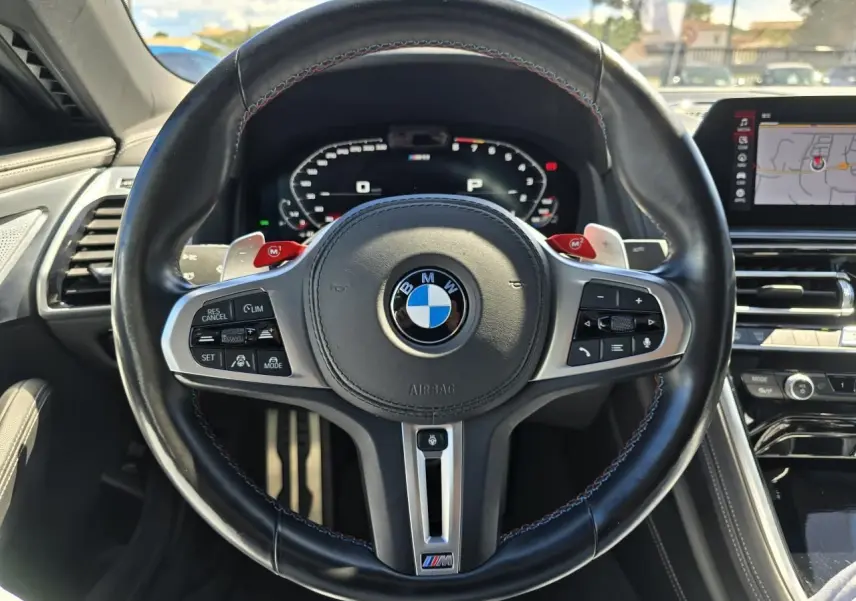 Volant noir en cuir avec logo BMW M, affichage numérique et tableau de bord du BMW Série 8 Cabriolet M8 Competition 2021.