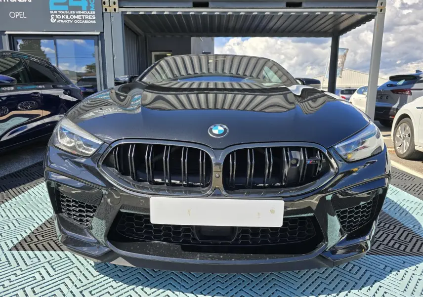 Vue frontale d'une BMW Série 8 Cabriolet M8 Competition noire avec calandre noire brillante et phares LED.