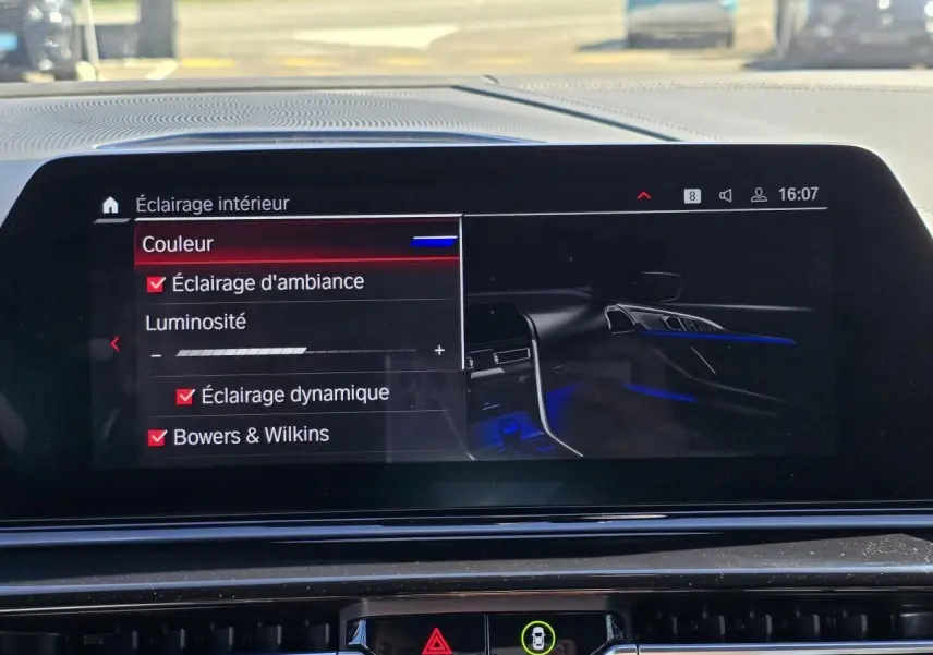 Écran central de la BMW Série 8 Cabriolet M8 Competition 2021 affichant les réglages d'éclairage d'ambiance bleu intérieur.