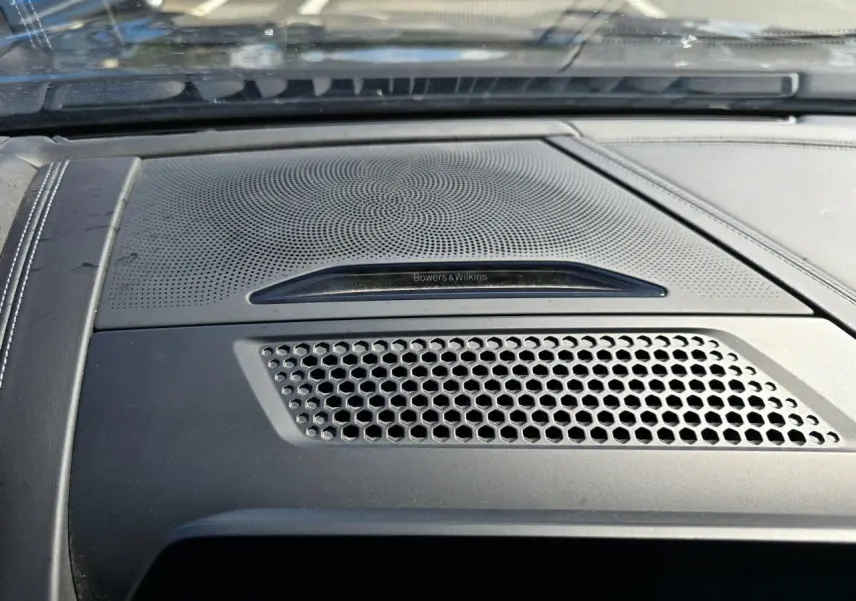 Gros plan sur la grille d'enceinte Bowers & Wilkins intégrée au tableau de bord noir du BMW Série 8 Cabriolet M8 Competition.